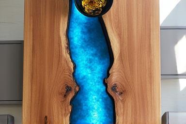 Modern dining table with a 'river' of blue epoxy resin running through live edge wood